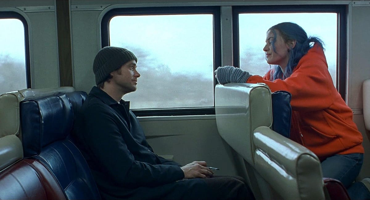 Jim Carrey as Joel and Kate Winslet as Clementine talking on a Long Island Rail Road train in Eternal Sunshine of the Spotless Mind.